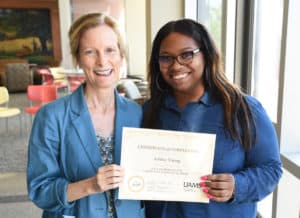 Kate Stewart, M.D., MPH, (left) who leads the Community Scientist Academy, presents a graduation certificate to Ashley Young.