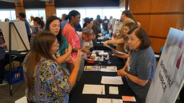 Nancy Gray, Ph.D., (right, front) president of BioVentures LLC, helped visitors to her booth understand the services BioVentures provides to UAMS researchers. 