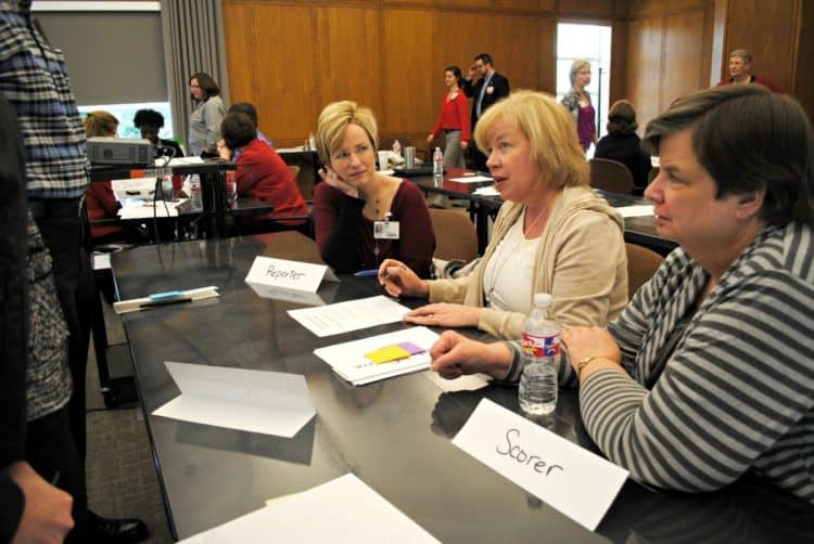 TRI Director Laura James, M.D., and TRI Leadership Council members Mary Aitken, M.D., and Paula Roberson, Ph.D., discuss an exercise during Lean training. 