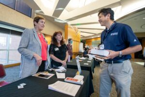 Zhong Su, Ph.D., talks to Nancy Rusch, Ph.D., and Pam Kahler, representing TRI’s Health Sciences Innovation and Entrepreneurship Training Program for postdoctoral fellows.