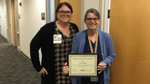 TRI's Tracy Thurman (right) received the UAMS Compliance Champion Award from Amy Jones, senior director of UAMS Clinical Billing Compliance.