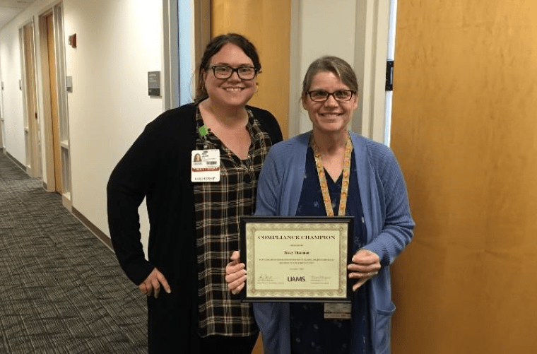 TRI's Tracy Thurman (right) received the UAMS Compliance Champion Award from Amy Jones, senior director of UAMS Clinical Billing Compliance. 
