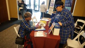 Crystal Crosswell, representing the UAMS Winthrop P. Rockefeller Cancer Institute, assists Thelma Shorter, who signed up to receive a colorectal screening kit.