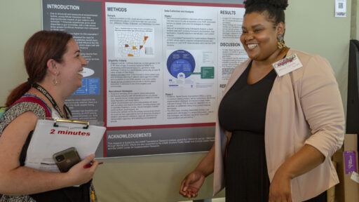 Nakita Lovelady, Ph.D. (right), shares a laugh with Melissa Zielinski, Ph.D., during the Research Day poster session.