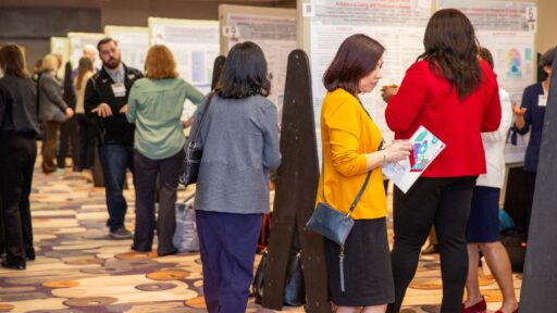 Jessica Presley, MPP, checks her TRI Research Day 2024 program during the poster session.