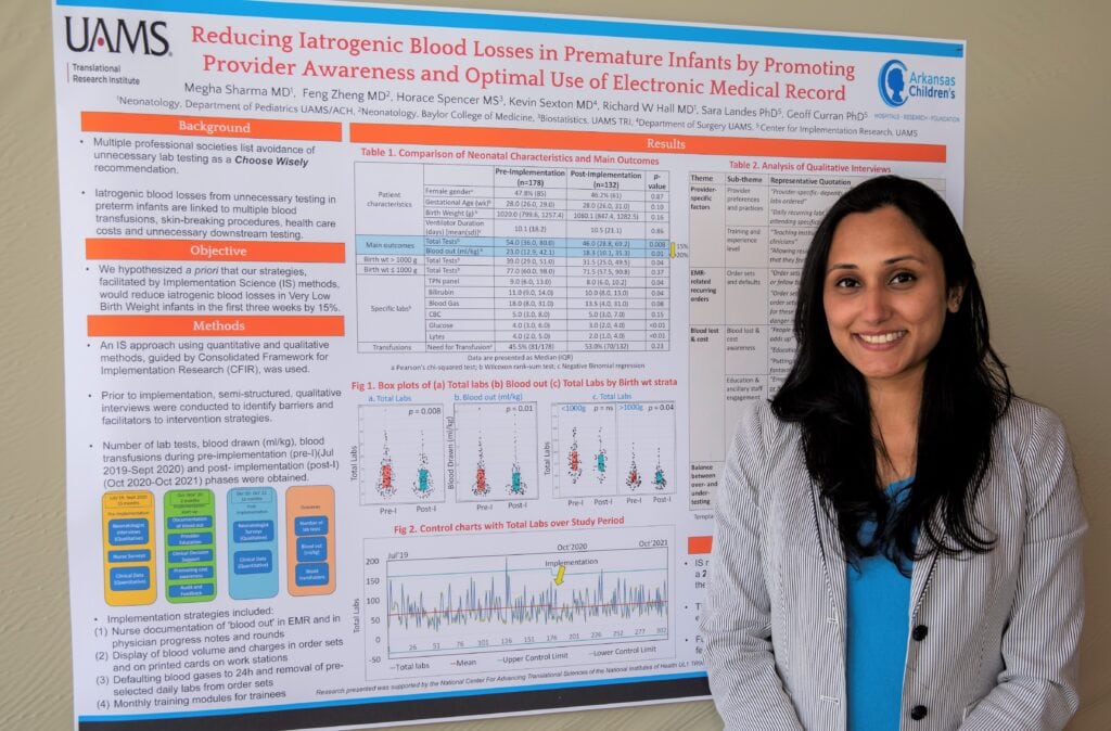 Megha Sharma, M.D., poses with a poster about her work.