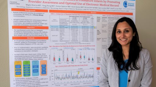 Megha Sharma, M.D., poses with a poster about her work.