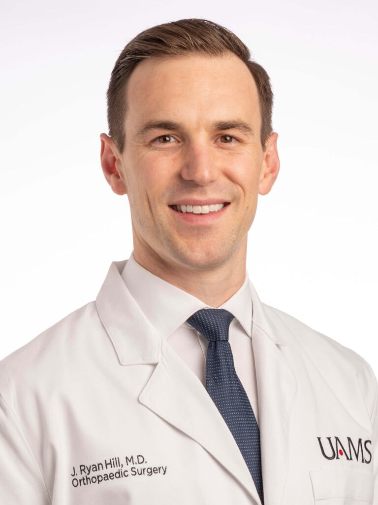 J. Ryan Hill is a white man with short brown hair and wearing a lab coat.