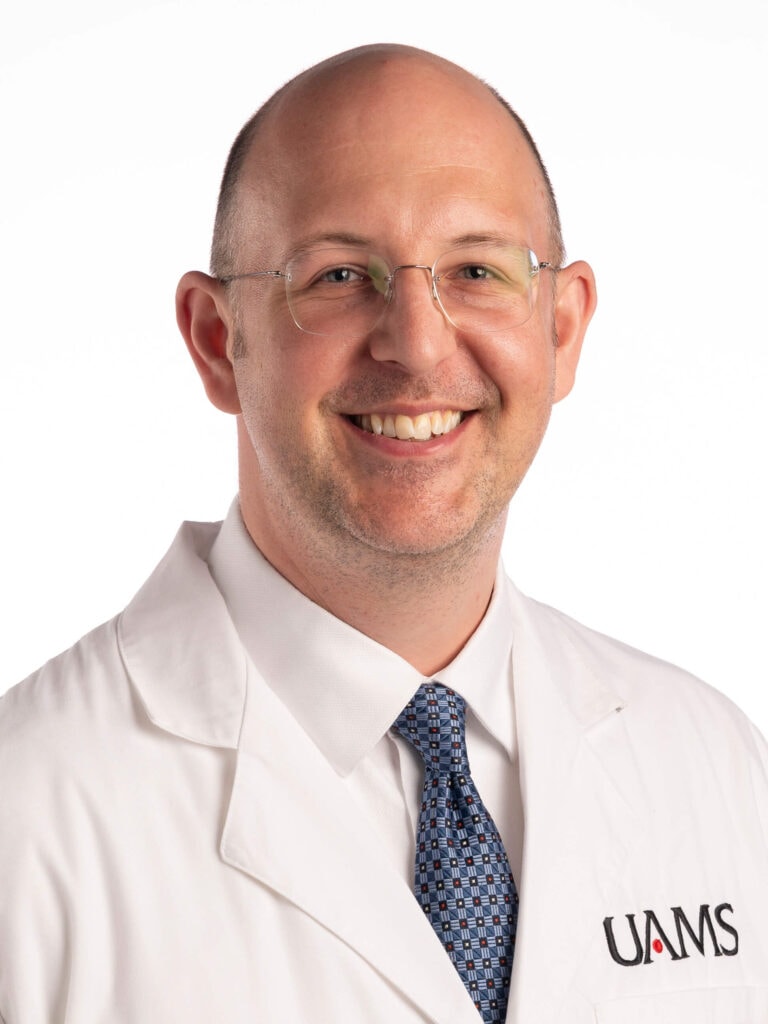 John R. Montgomery is a white man wearing glasses and a lab coat.