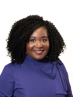 Krishna Ellington is a woman with black hair and wearing a purple top.