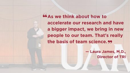 Photo of Laura James on stage. She is wearing green and black top with black pants. Quote on image reads: “As we think about how to accelerate our research and have a bigger impact, we bring in new people to our team. That's really the basis of team science.”